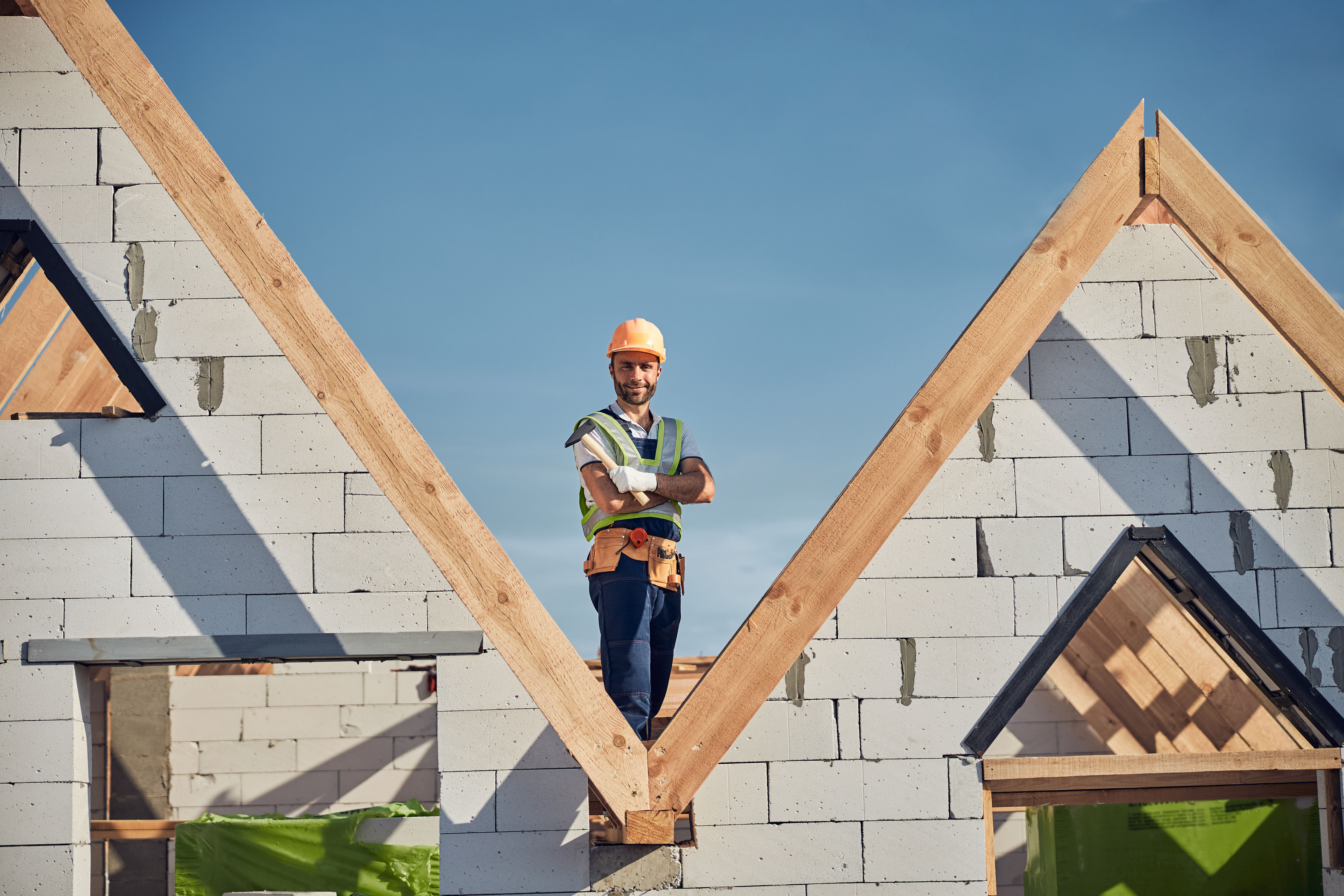 Confident professional roofer standing on a build